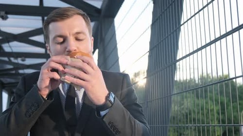 Businessman Eats a Tasty Burger Fast Street Food