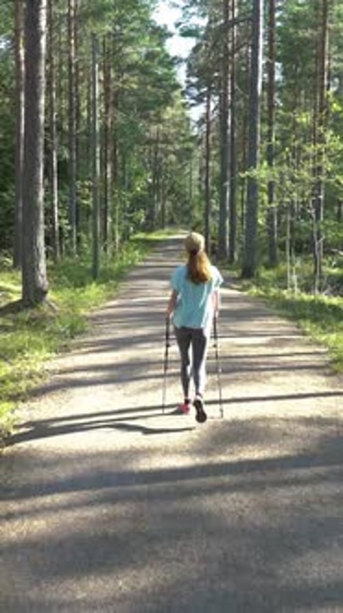Active Woman Doing Nordic Walking in a Park