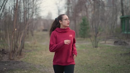 Woman Running in Park on Overcast Day