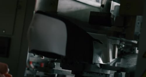 Macro of a shoemaker using a professional machine to bend the shoes and fix them according to the