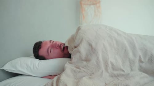 Man Sleeping Peacefully, Stretches and Smiles in Bed