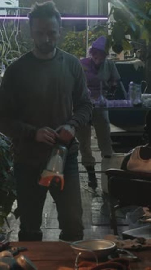 Man Repairing Lamp with Screwdriver in Post Apocalypse Bunker