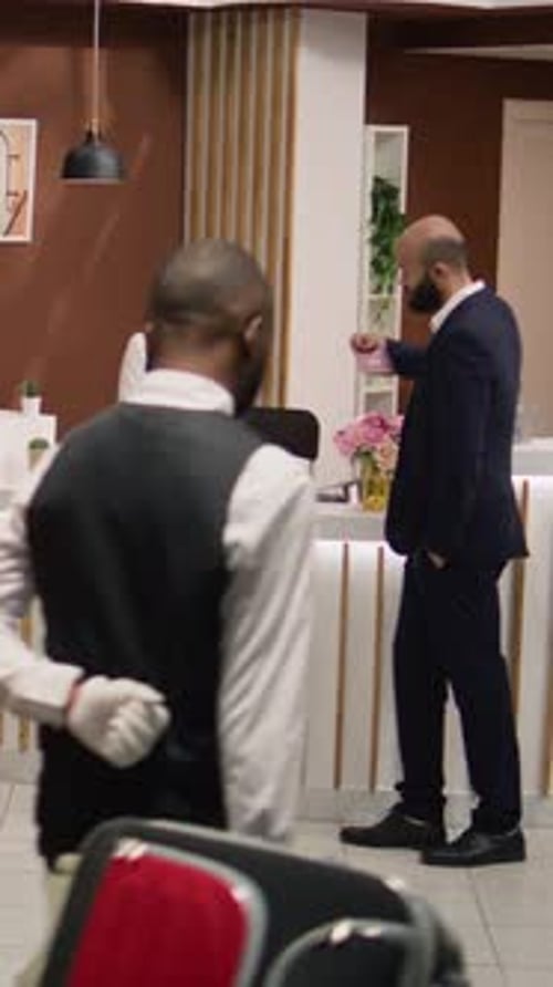 Man Checks into Hotel Talking to Receptionist