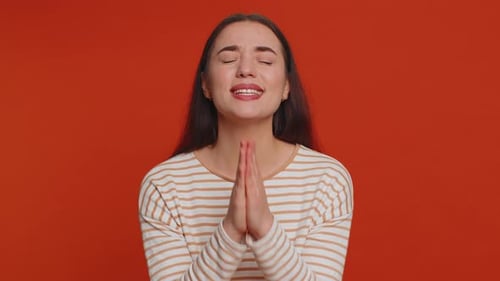 Young Woman Begs and Pleads with Clasped Hands