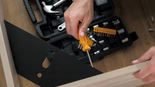 Assembling Furniture with Screwdriver and Toolbox