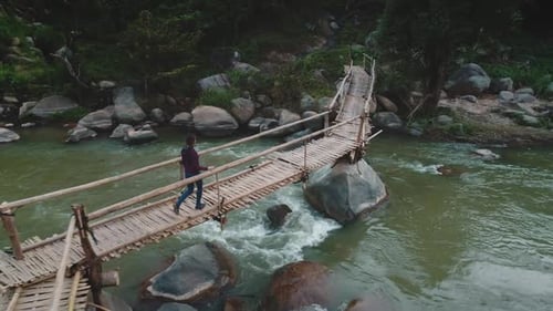 Crossing a Rustic Wooden Bridge Over a River