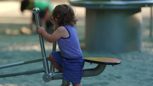 Toddler stepping down from playground digger with initial difficulty then successfully getting off