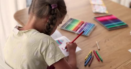 Child Drawing with Markers at Wooden Table