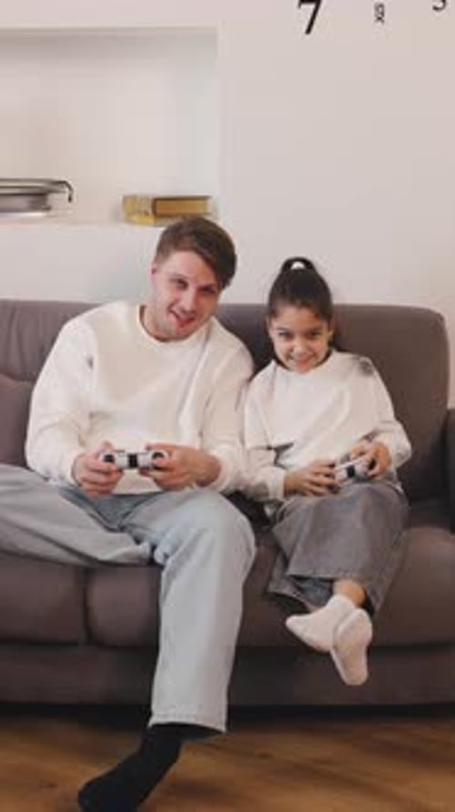 Father and Daughter Smiling Playing Video Games