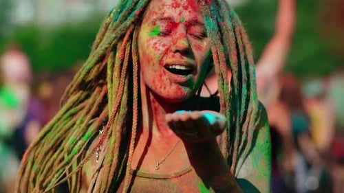 Woman Covered in Holi Powder Blows Colorful Dust
