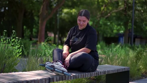 young hipster girl wearing roller skates tying laces in skate park before skating street extreme
