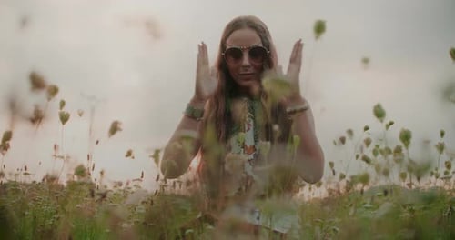 Woman with Sunglasses in Wildflower Meadow at Sunset