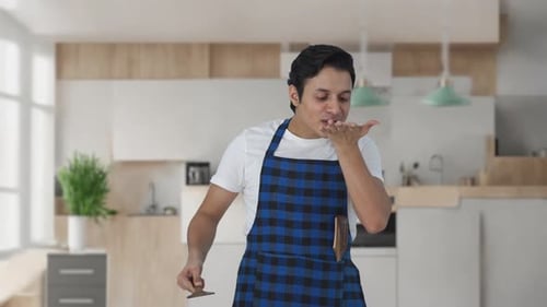 Man Tasting Food, Grimacing in Kitchen
