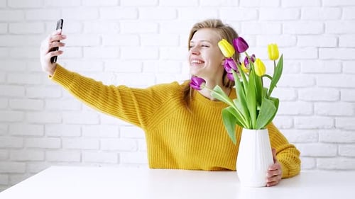 Smiling Woman Taking Selfie with Yellow Tulips