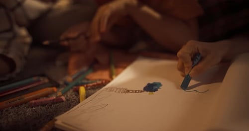 Close Up On Hands Of Happy Korean Family Drawing Together in Notebook With Pens And Pencils. S