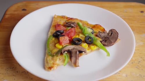 Zoom at Vegetarian pizza with olives, mushrooms, green paprika, tomato, and corn