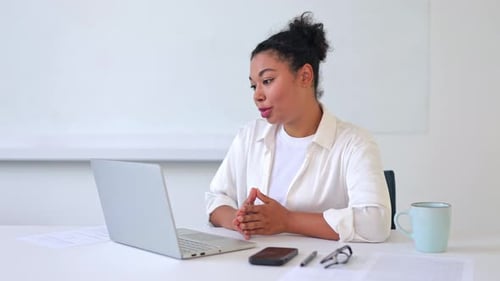 Woman Communicating on Laptop Video Call at Desk