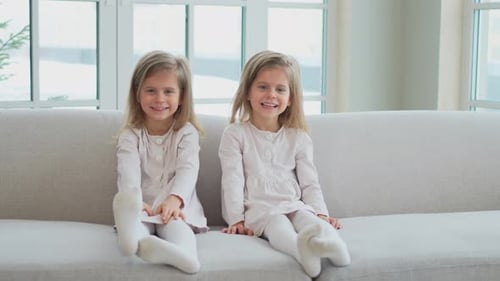Happy Young Girls Smiling Together on Couch