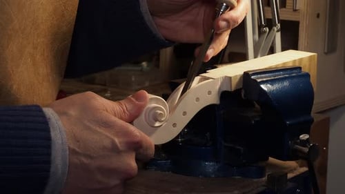 Master Luthier Hand Carving the Scroll of a Violin Headstock in Workshop