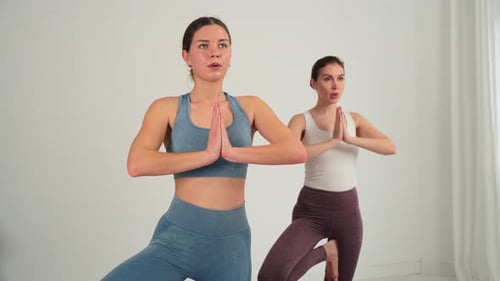 Two Women Doing Yoga in a Bright Room