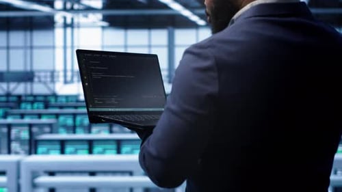 Programmer in Data Center Doing Yearly Maintenance Checkup Using Laptop