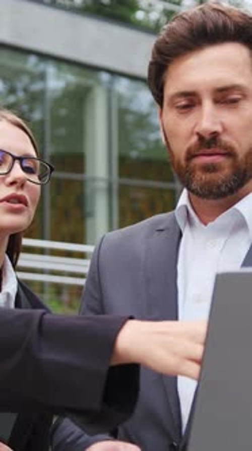 Business Professionals Discussing Work Using a Tablet Outdoors