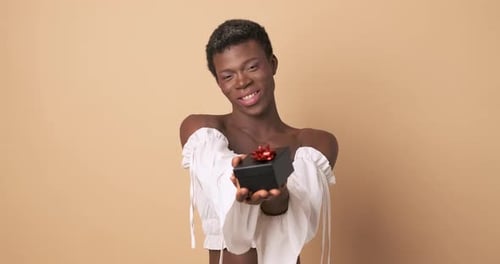 Afrikanische Transgender-Person, die einer Person ein Geschenk macht