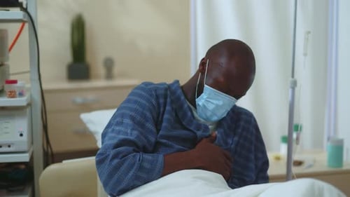 Hospital Lights Off Weak Infected Unhealthy Afroamerican Patient in Face Mask Dying on Hospital Bed