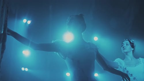 Two Ballet Dancers Performing on Stage Under Blue Light