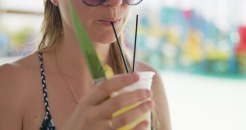 Young Woman Sips Tropical Cocktail