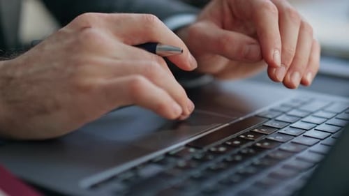 Man Using Laptop Trackpad in Professional Setting