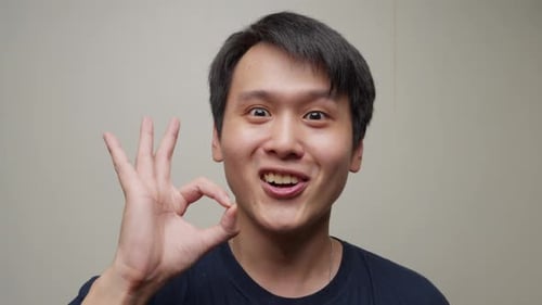 Man Showing OK Hand Gesture and Smiling