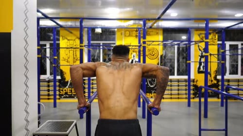 Strong African Man Doing Push Ups on Parallel Bars at Sport Club Muscular Afro American Sportsman