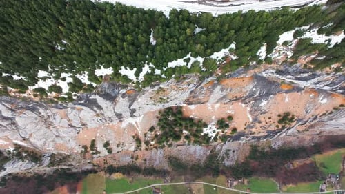 Aerial ascend over steep vertical mountain wall canyon in Switzerland