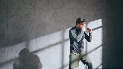 Angry Fighter Practicing Kicks at Speed Intensity Training Man Fighting at Gym