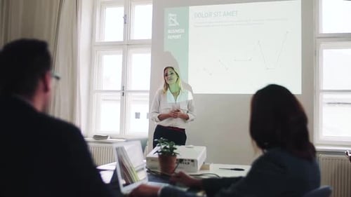 A Businesswoman Giving a Presentation to Colleagues in a Modern Office