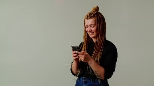 Happy Woman Using Smartphone in Studio