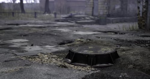 Gritty Manhole Cover Opening in Urban Decay Scene
