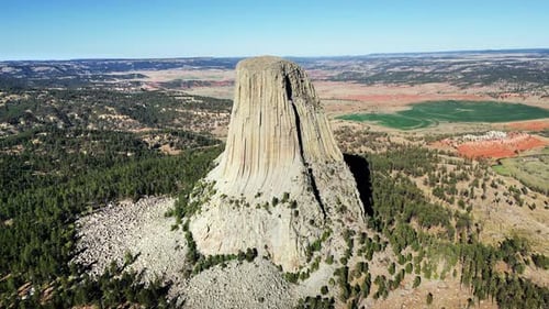 Aerial drone view of Devils Tower National Monument rising dramatically above the surrounding landsc