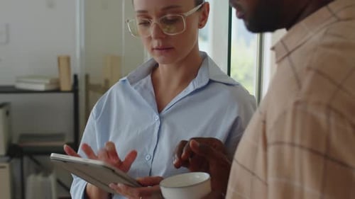 Young Employees Using Tablet Computer while Working at Office