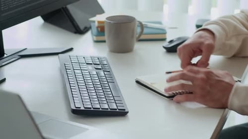 Les mains d'un spécialiste prennent des notes lors de la saisie sur le clavier au bureau