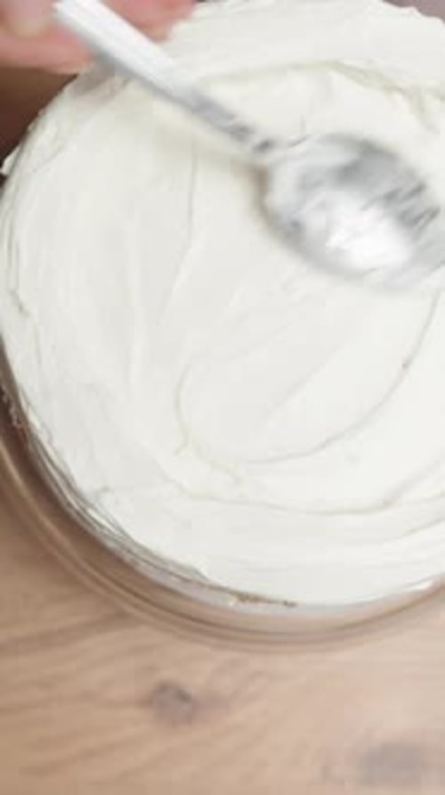 Cake Being Decorated with Cream Frosting