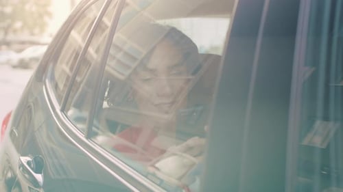 Woman riding in car using phone