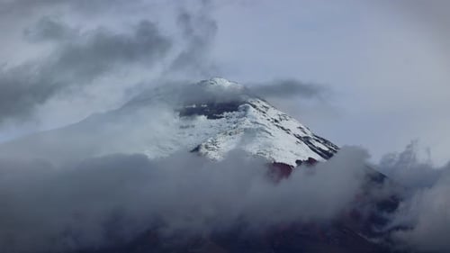 panoramic view of snow-capped Cotopaxi volcano (5,897 m) emerging from clouds, Ecuador