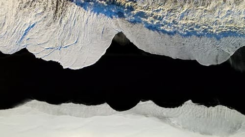 Aerial view of black sand beach and waves, Iceland.