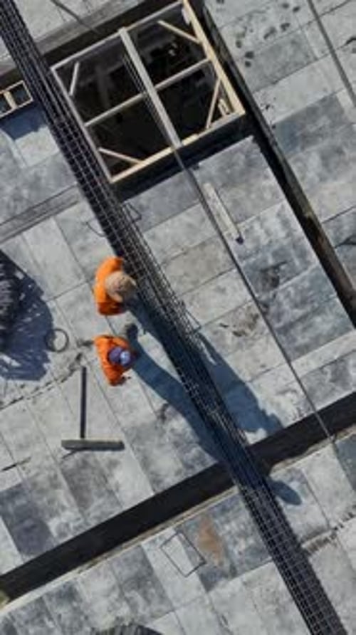 Vídeo vertical de trabajadores trepando andamios y arreglando piezas metálicas