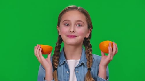 Closeup Funny Girl Licking Orange Smiling Looking at Camera Grimacing on Green Screen Portrait of