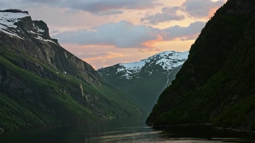 Incrível paisagem montanhosa coberta de neve com um pôr do sol colorido e vívido em Geiranger, Noruega
