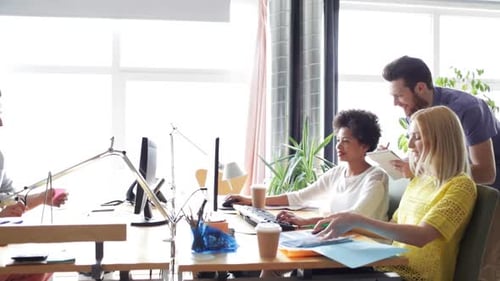 Conceito de negócios, startups e pessoas - equipe criativa feliz com computadores e pastas discutindo...