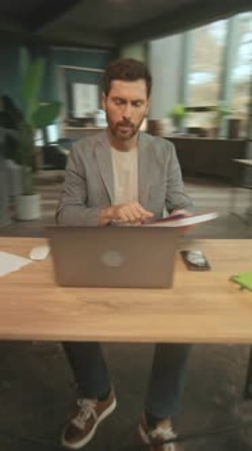 Die Person bewertet digitale Simulationen sorgfältig, während sie von Zimmerpflanzen und Organisation umgeben ist